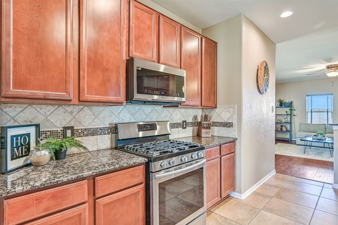 4206 Brightridge Court Rosenberg, TX 77471 - Photo 12 of 27 The kitchen offers open sightlines into the adjoining living spaces and a full suite of stainless appliances, including a concealed control dishwasher, a gas cooktop, a single oven, a venthood microwave, and a dual basin undermount sink.