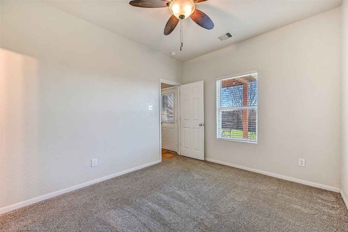 4206 Brightridge Court Rosenberg, TX 77471 - Photo 15 of 27 The first floor hosts a guest suite/secondary bedroom featuring plush carpet flooring, a lighted ceiling fan, and a window with backyard views. A Jack & jill style bathroom is accessible from this bedroom as well as from a hallway near the dining room.