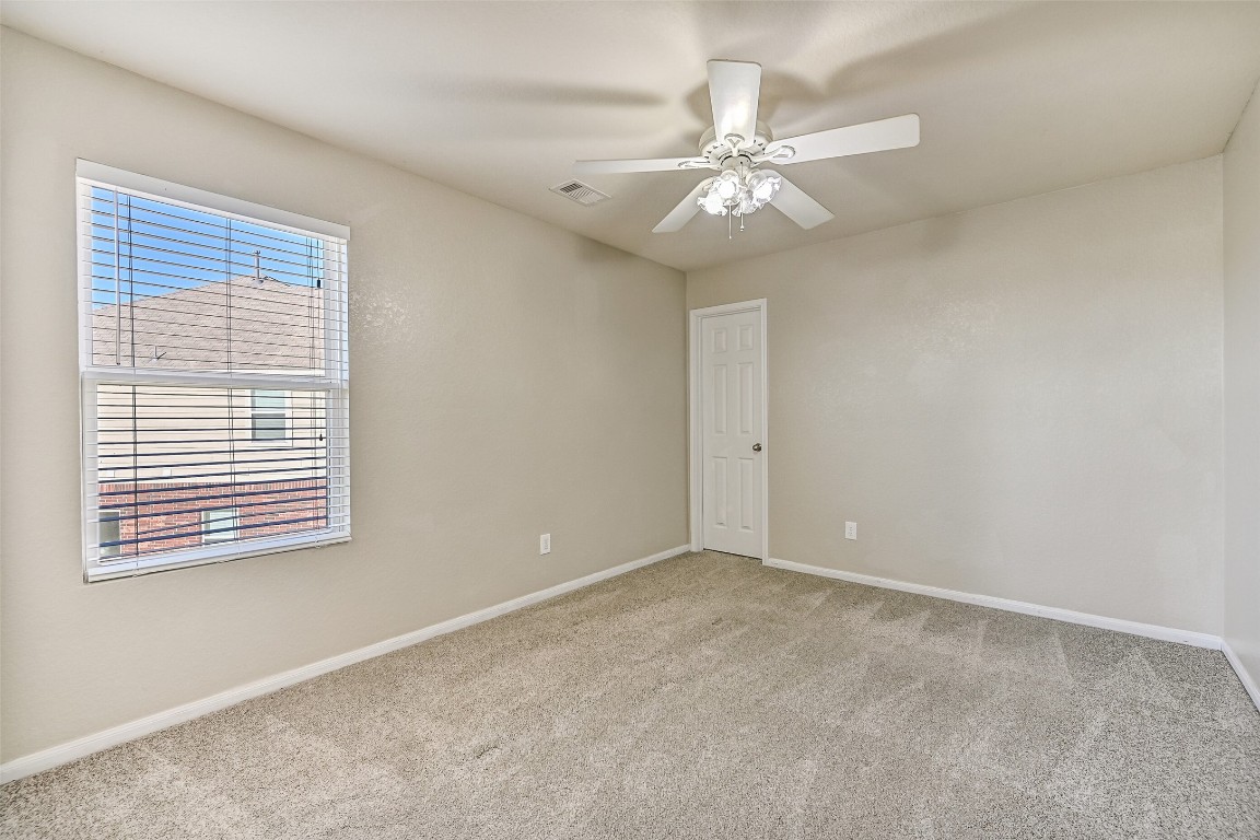 4206 Brightridge Court Rosenberg, TX 77471 - Photo 20 of 27 Another secondary bedroom features neutral finishes, a lighted ceiling fan, a side facing window, and comfortable living space.