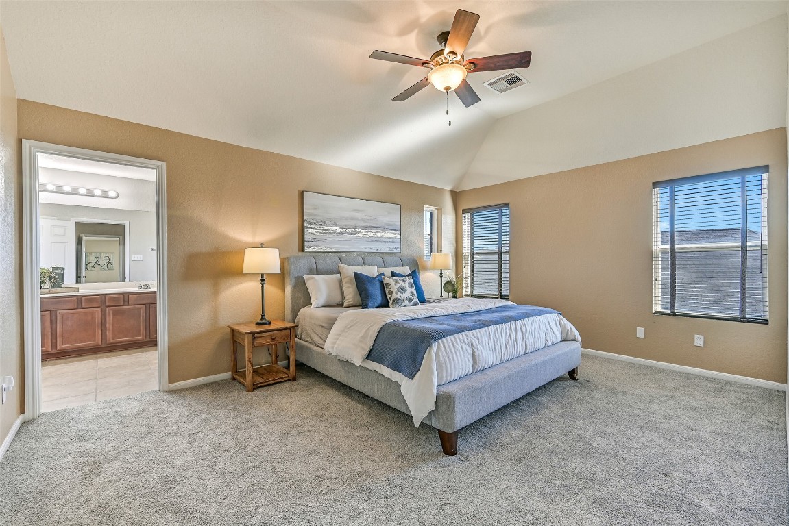 4206 Brightridge Court Rosenberg, TX 77471 - Photo 23 of 27 In the private second floor primary suite, you'll find an elevated gambrel ceiling with a lighted ceiling fan, plush carpet, neutral paint, numerous windows with 2-inch blinds, and an ensuite bathroom.