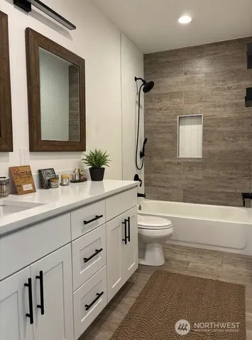 a bathroom with a granite countertop toilet a sink and a bathtub
