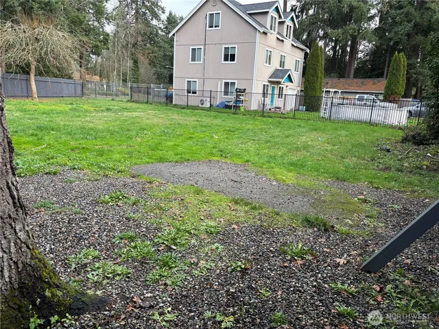 a view of a house with backyard and a tree