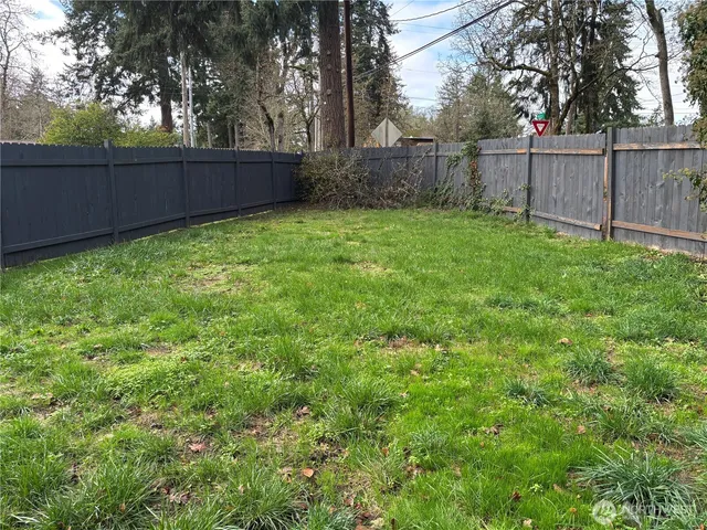 a view of a backyard with wooden fence