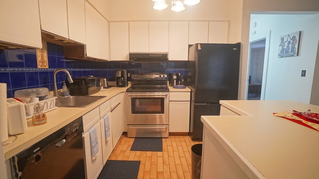 140 Chestnut Street, Unit 314 Springfield, MA 01103 - Photo 9 of 21 a kitchen with a sink a refrigerator and cabinets