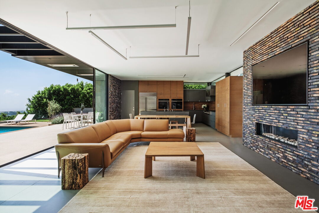 2200 Stradella Road Los Angeles, CA 90077 - Photo 7 of 27 a living room with fireplace furniture and a flat screen tv