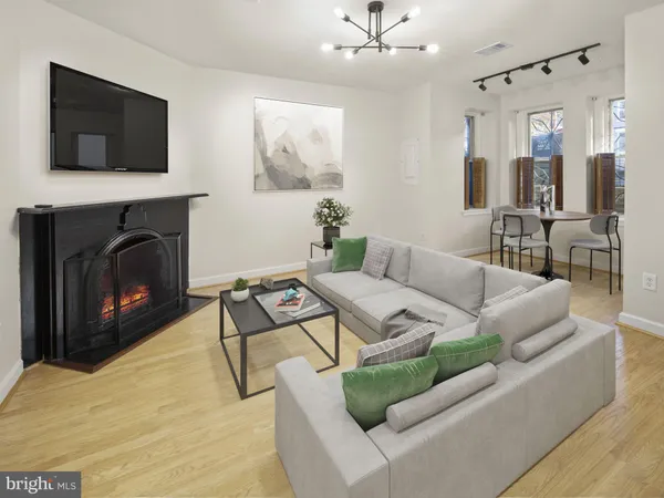 a living room with furniture a flat screen tv and a fireplace