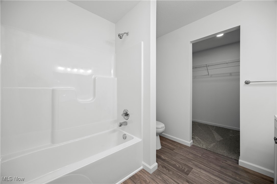 1999 East Oldgate Road Sandusky, OH 44870 - Photo 23 of 32 Bathroom with a walk in closet, vanity, shower / bathtub combination, and dark wood-style floors