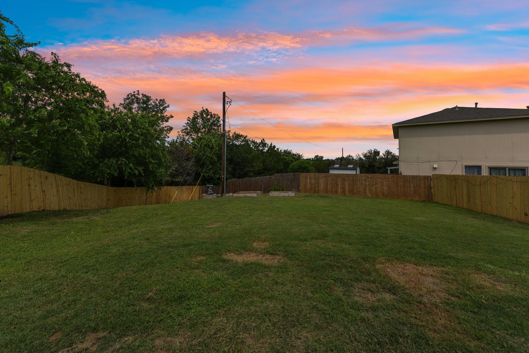 5405 Rusk Court Austin, TX 78723 - Photo 39 of 40 A spacious, grassy backyard provides a blank canvas for outdoor aspirations, secured by new wood fencing.