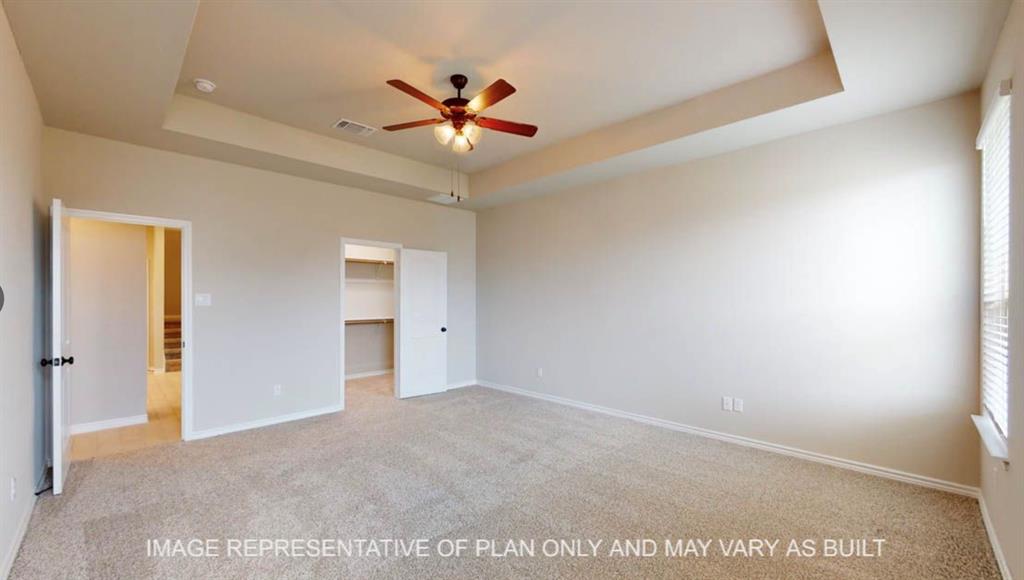10720 Granada Drive Waco, TX 76708 - Photo 11 of 25 Unfurnished bedroom featuring a raised ceiling, light carpet, a walk in closet, and ceiling fan