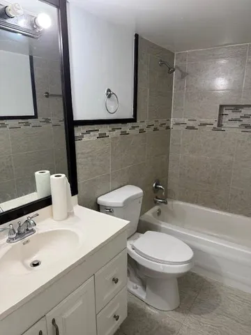 a white toilet sitting next to a bath tub and shower