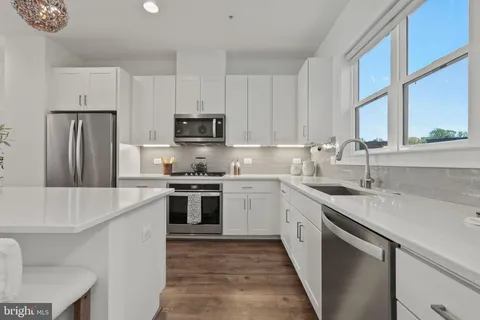a large kitchen with kitchen island a lot of counter space and a wooden floor