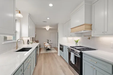 a kitchen with stainless steel appliances a sink stove and cabinets