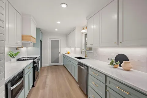 a kitchen with a sink a stove and cabinets