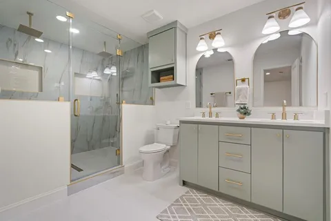a bathroom with a sink a toilet and shower