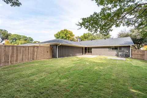 a backyard of a house with table and chairs