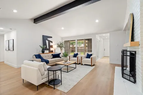 a living room with furniture a fireplace and a large window