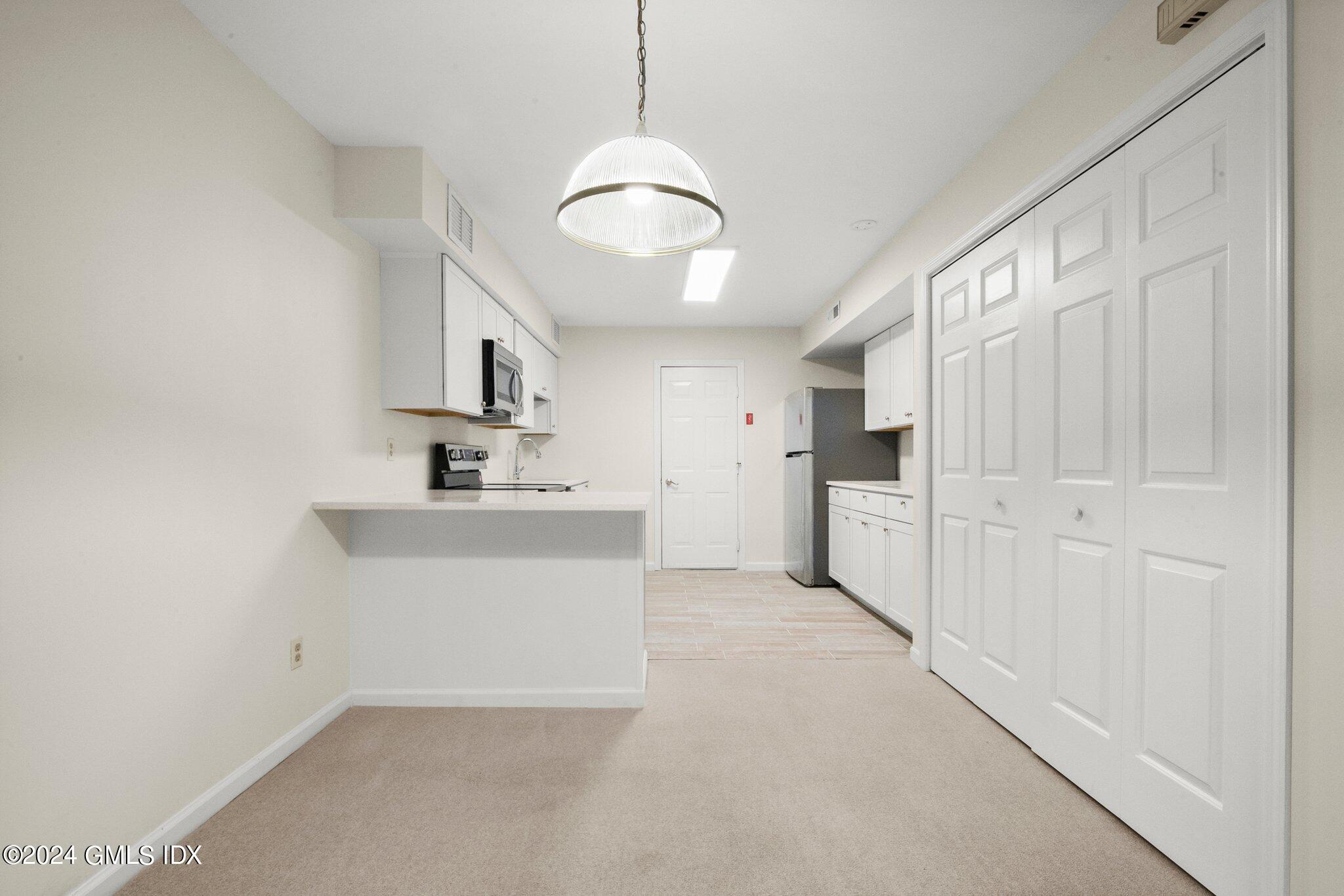 351 Pemberwick Road, Unit 109 Greenwich, CT 06831 - Photo 5 of 9 a bathroom with a sink a mirror and a light fixture