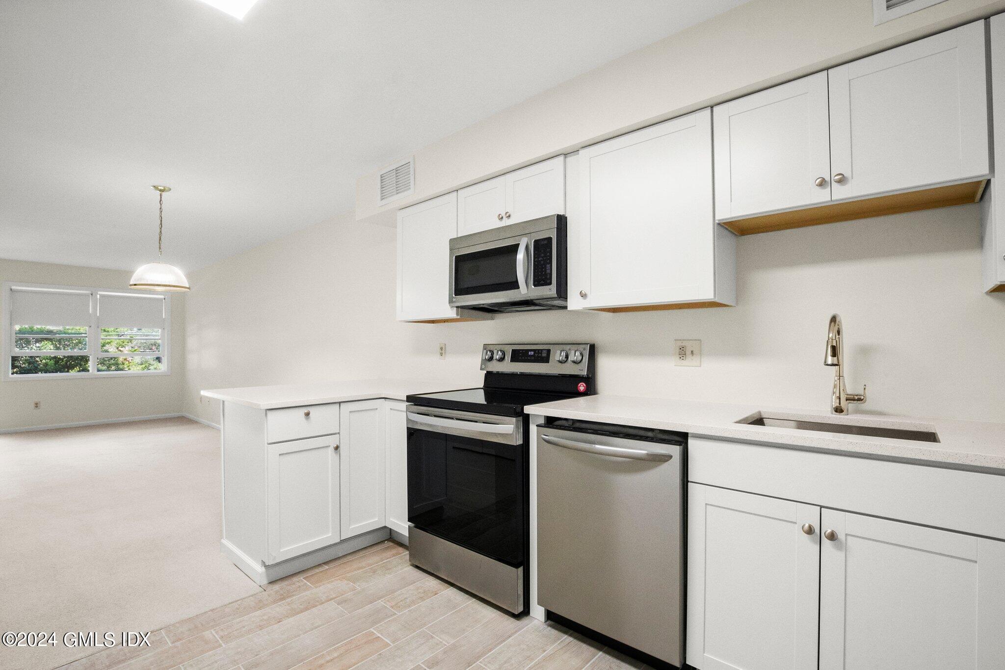 351 Pemberwick Road, Unit 109 Greenwich, CT 06831 - Photo 6 of 9 a kitchen with a sink cabinets and stainless steel appliances