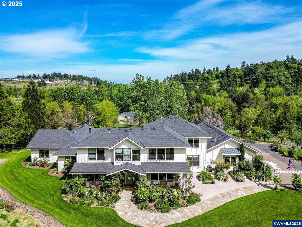 an aerial view of a house with yard and green space