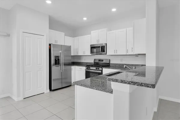 a kitchen with stainless steel appliances granite countertop a refrigerator sink and stove