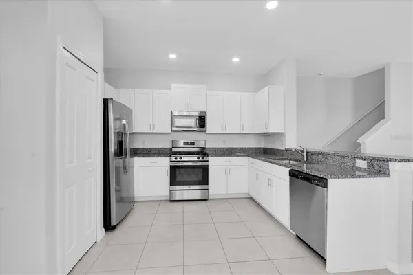a kitchen with stainless steel appliances granite countertop a refrigerator and a sink