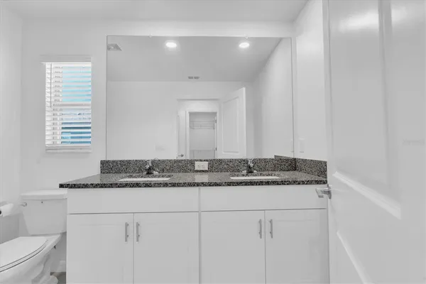 a bathroom with a granite countertop sink and a mirror