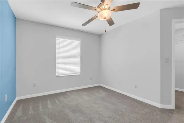 an empty room with a window and a fan