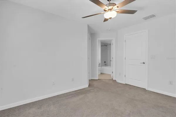 an empty room with a ceiling fan and a window