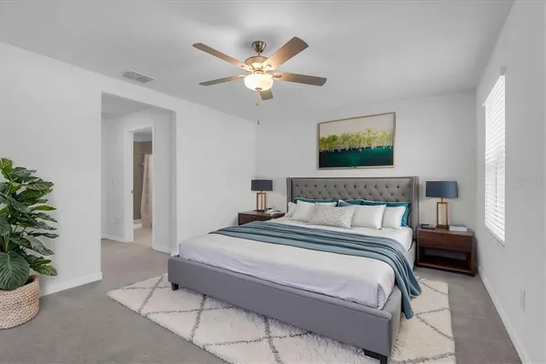 a bedroom with bed and a potted plant