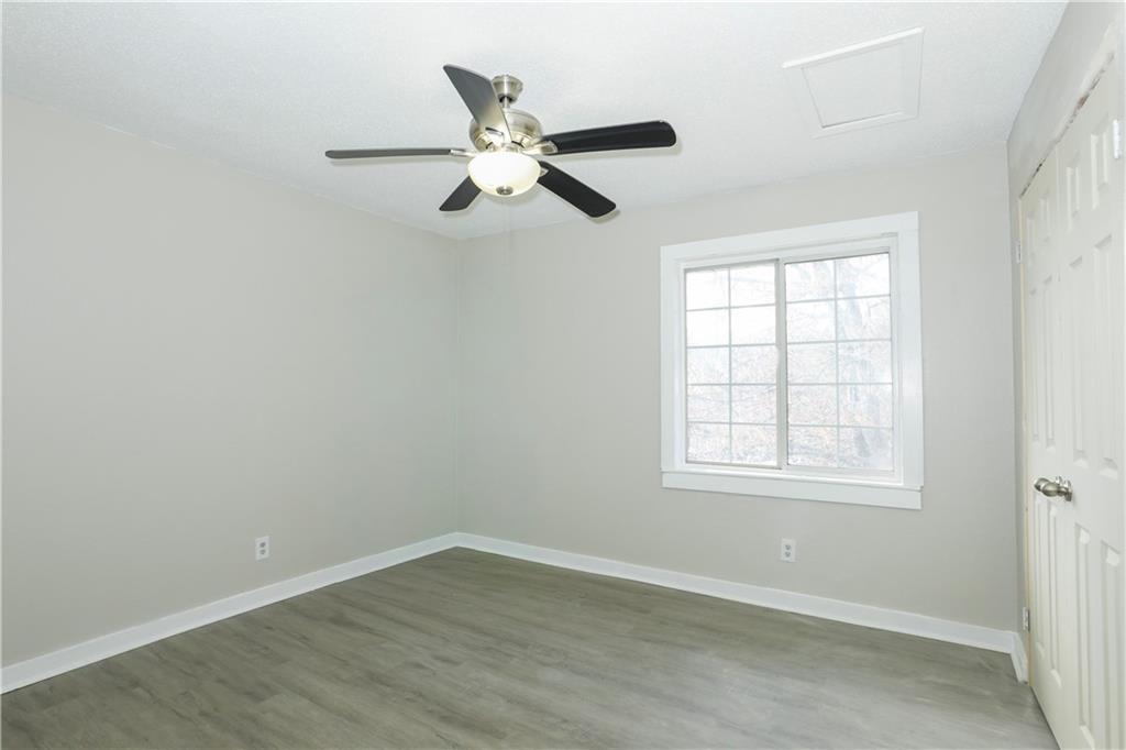 2055 Alison Court Southwest, Unit 8 Atlanta, GA 30311 - Photo 6 of 12 an empty room with wooden floor fan and windows