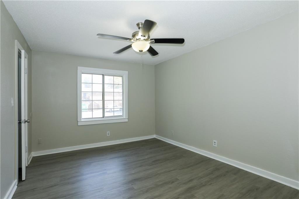 2055 Alison Court Southwest, Unit 8 Atlanta, GA 30311 - Photo 7 of 12 an empty room with wooden floor chandelier fan and windows