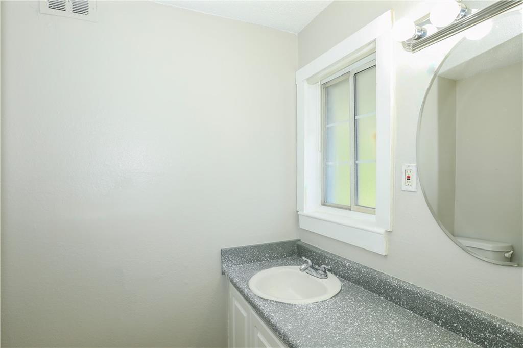 2055 Alison Court Southwest, Unit 8 Atlanta, GA 30311 - Photo 9 of 12 a bathroom with a granite countertop sink and a mirror