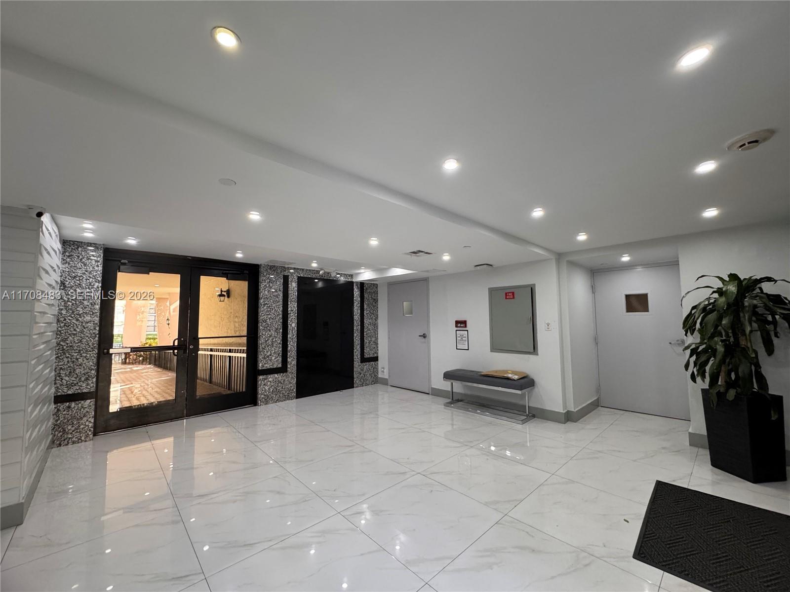 16919 North Bay Road, Unit 117 Sunny Isles Beach, FL 33160 - Photo 2 of 20 a living room with furniture and a potted plant
