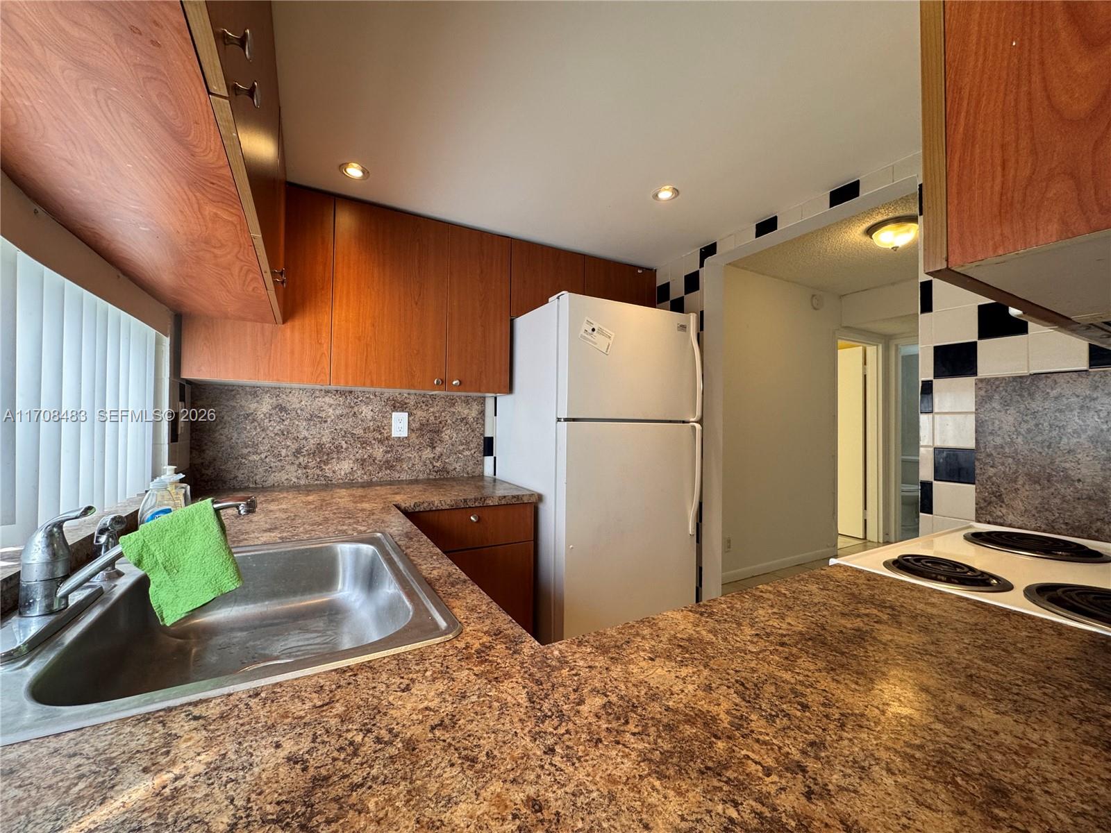 16919 North Bay Road, Unit 117 Sunny Isles Beach, FL 33160 - Photo 6 of 20 a kitchen with refrigerator and window