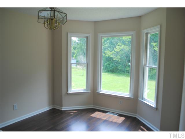 232 Pope Lake Road Angier, NC 27501 - Photo 8 of 15 a view of an empty room with wooden floor and windows