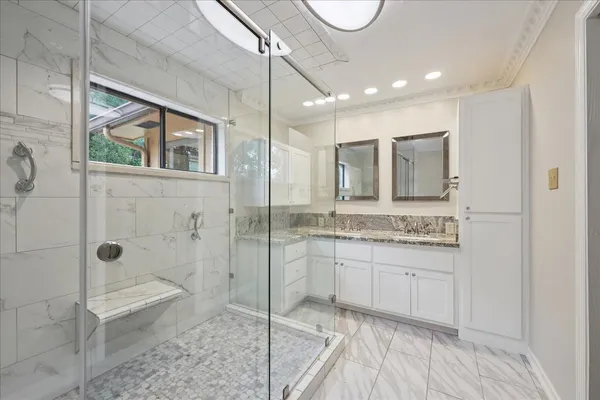 a bathroom with a granite countertop sink mirror and shower