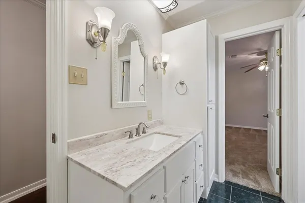a bathroom with a granite countertop sink a mirror and a shower