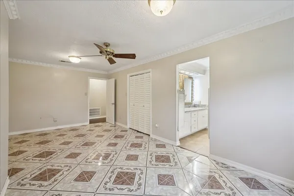 a view of a livingroom with a chandelier fan and wooden floor