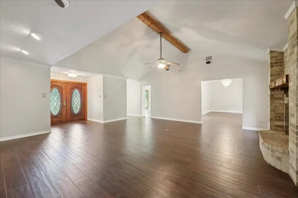 a view of an empty room with wooden floor and a cabinet