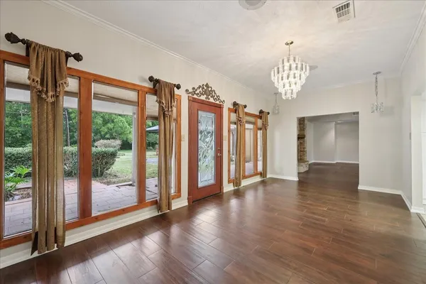 a view of a livingroom with a furniture wooden floor and chandelier