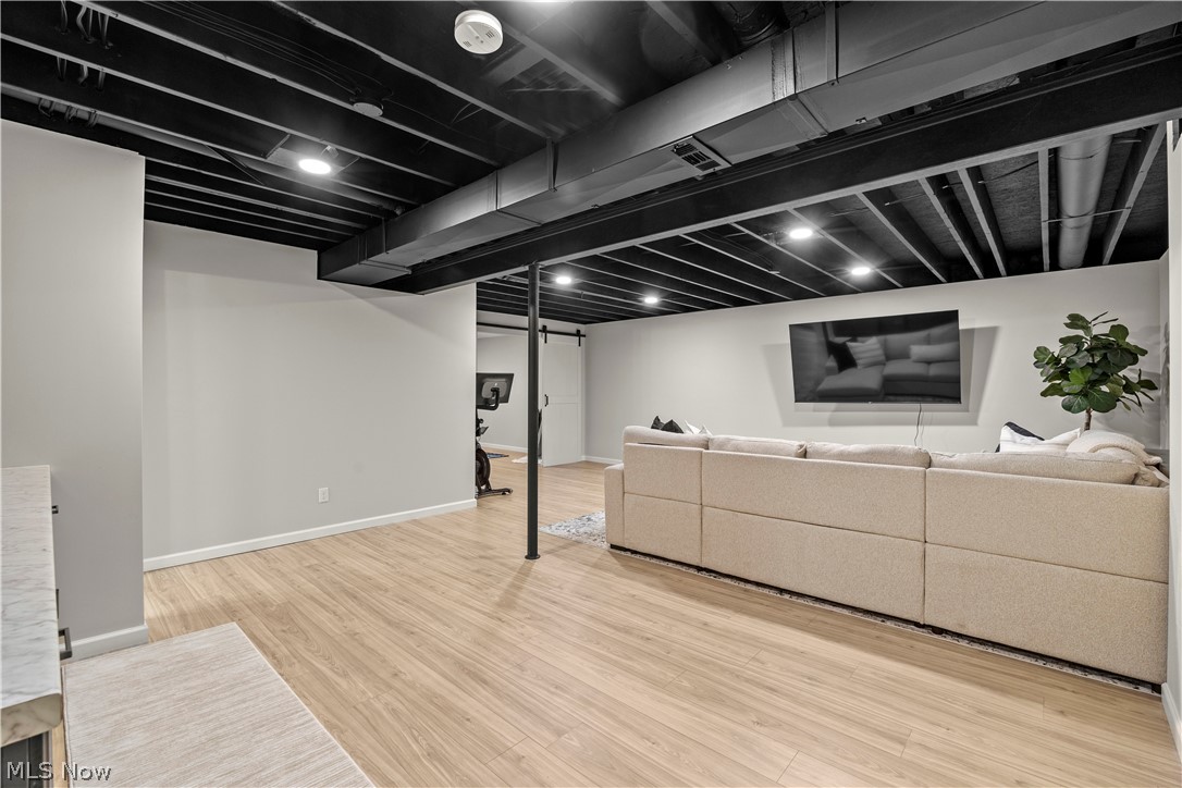 2161 Fowl Road Elyria, OH 44035 - Photo 29 of 46 Open concept recreational space featuring light wood-finish flooring, recessed lighting, and a painted exposed joist ceiling