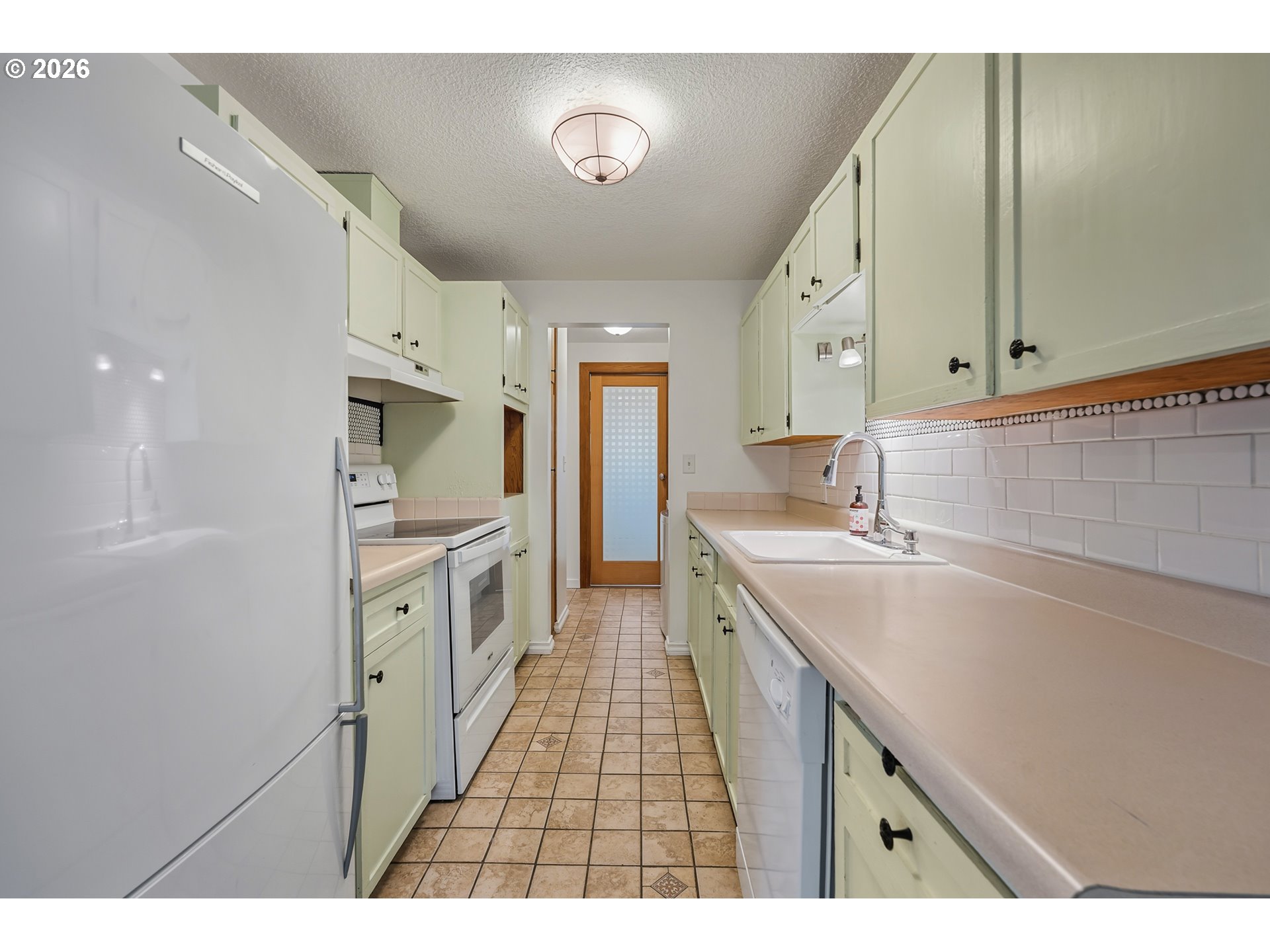5566 Southwest Erickson Avenue Beaverton, OR 97005 - Photo 11 of 31 a kitchen with a sink stove and cabinets