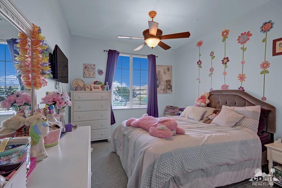 37388 Haweswater Road Indio, CA 92203 - Photo 17 of 28 a bedroom with a bed and a chandelier
