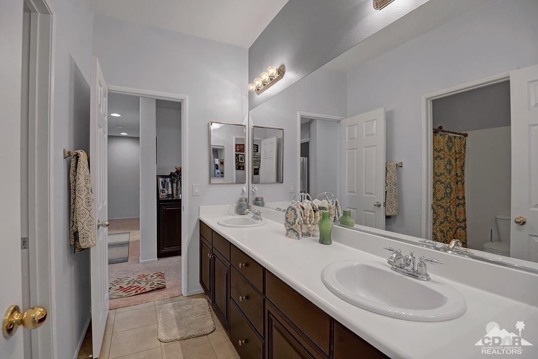 37388 Haweswater Road Indio, CA 92203 - Photo 18 of 28 a bathroom with a sink double vanity granite tub shower and a mirror
