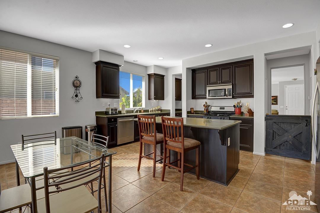37388 Haweswater Road Indio, CA 92203 - Photo 6 of 28 a open kitchen with granite countertop a stove a sink a dining table and chairs