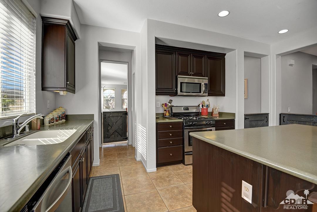 37388 Haweswater Road Indio, CA 92203 - Photo 7 of 28 a kitchen with stainless steel appliances granite countertop a sink stove and refrigerator