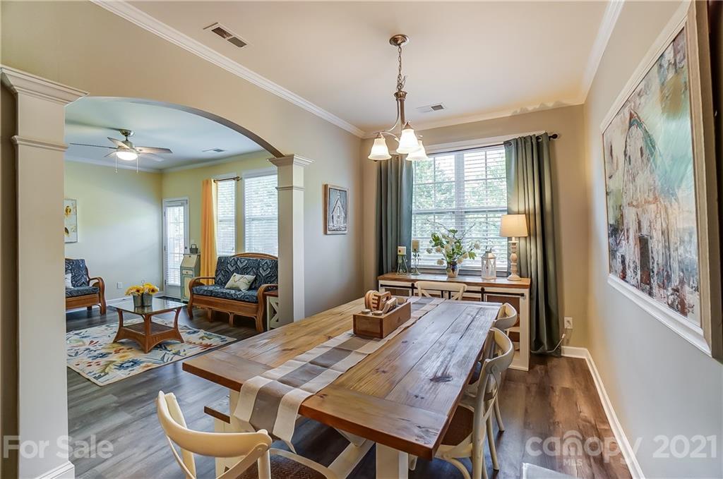 827 Solandra Way Fort Mill, SC 29708 - Photo 24 of 43 a dining room with wooden floor a chandelier a wooden table and chairs