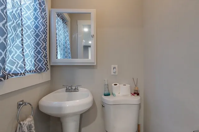 a bathroom with a sink and mirror with toilet