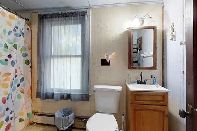 a bathroom with a toilet sink and mirror