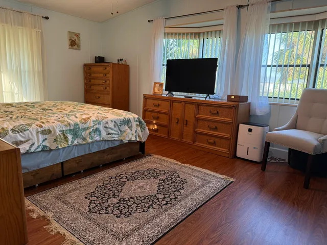 a bedroom with a bed window and a flat screen television